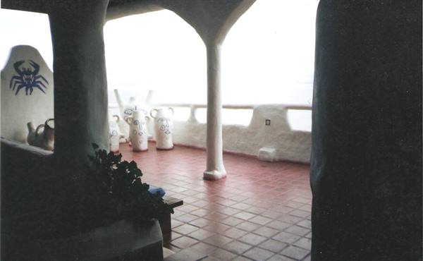White curved pillars terrace with painted amphorae and terracotta tiled floor