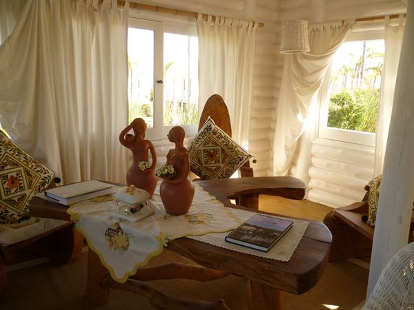 Terracotta figurines on rustic wooden table, white curtains and sunlight
