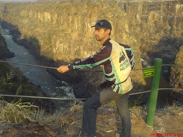 Man leaning on cable fence above the Zambezi gorge, Victoria Falls