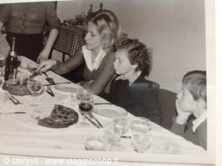 Woman and children at table with pizza and wine, vintage black and white photo