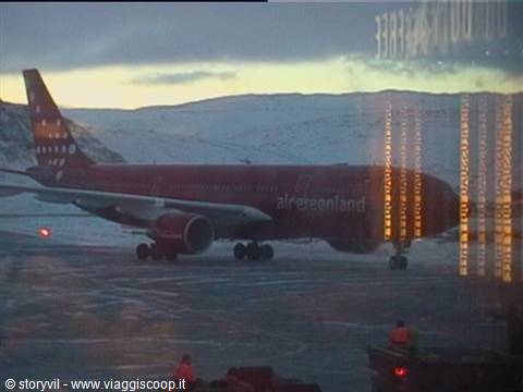 Red Air Greenland plane parked on snow at Kangerlussuaq, reflected in glass