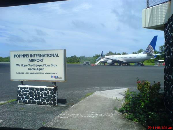Pohnpei International Airport sign in front of a parked Continental airplane on the tarmac