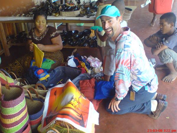 Tourist in tropical shirt at craft market among baskets and fabrics