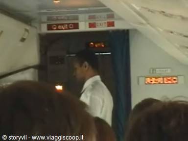 Crew member in white shirt near the airplane emergency exit