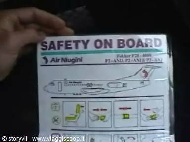 Hand holding an Air Niugini safety card from a Fokker