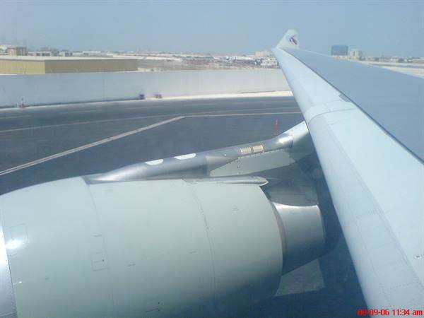 Qatar airplane wing and engine taxiing on the airport runway