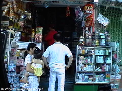 Family at a small grocery shop with snacks displayed on shelves