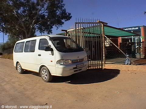White van parked outside the metal gate of Windhoek station