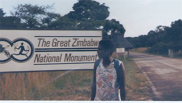 Woman next to the Great Zimbabwe National Monument roadside sign