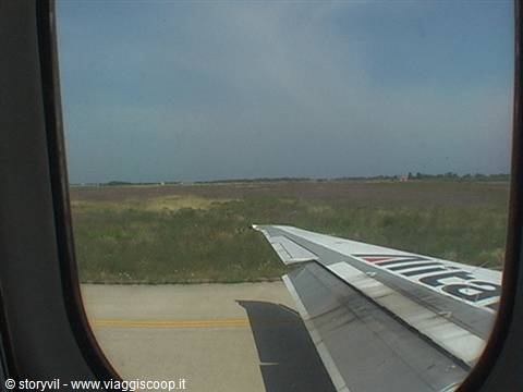 Airplane wing seen from the window while landing on the runway