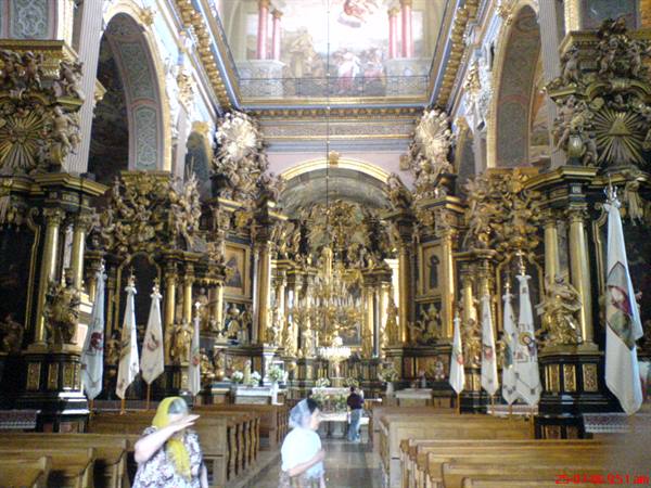 Baroque interior of Jasna Góra basilica in Częstochowa, gilded altars and worshippers