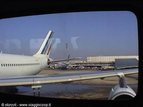 Air France tail with tricolor stripes at the airport, seen through the window