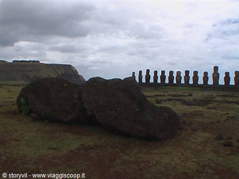 Fallen moai in foreground with row of statues on the ahu, Easter Island