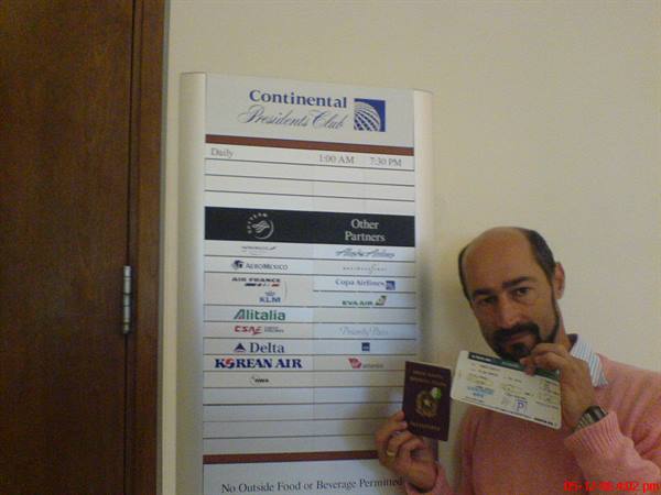 Man shows passport and boarding pass next to the Continental Presidents Club sign