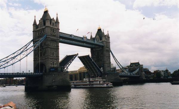 Tower Bridge in London with bascule raised, a boat passing underneath