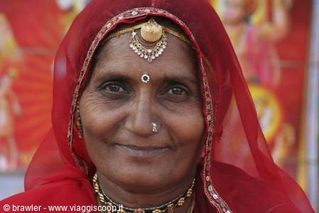 Smiling elderly woman wearing red veil, gold nose ring and bindi