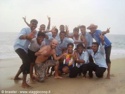 Tourist with group of cheerful young men posing on the beach