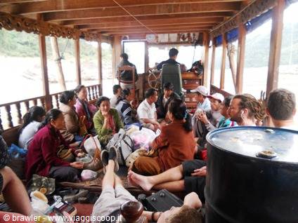 Travelers sitting on the wooden deck of a wooden river boat