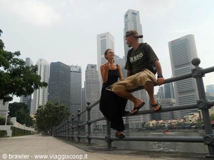 Couple sitting on the railing in front of Singapore skyscrapers