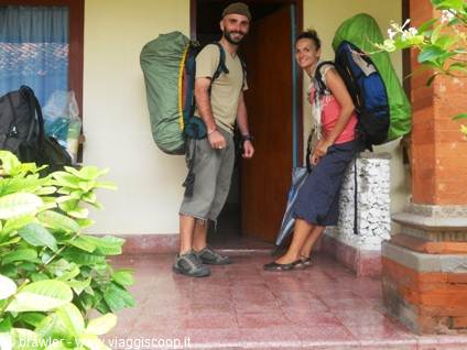 Two backpackers with huge packs outside a homestay doorway