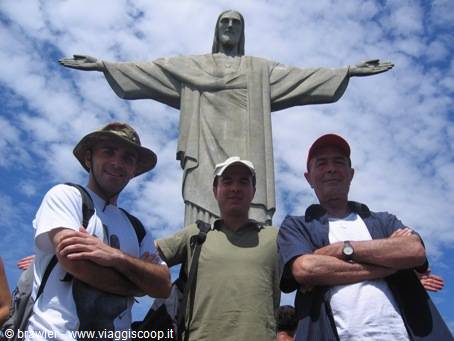 Three smiling tourists in front of Christ the Redeemer in Rio de Janeiro