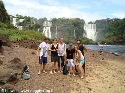 Group of tourists posing on the beach below Iguazú Falls