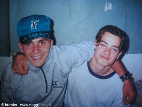 Two young friends hugging, one in a blue cap, scanned nineties photo