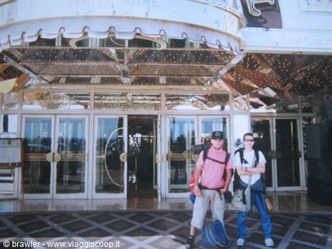 Two backpackers standing in front of a mirrored casino entrance