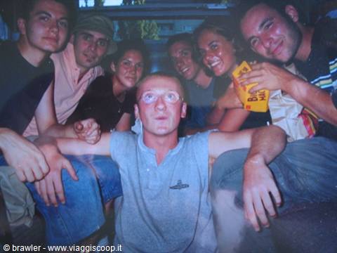 Group of friends crowded inside a van, one in the center wearing glasses