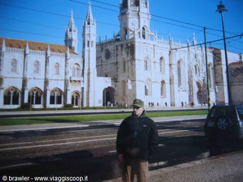 Man in cap standing in front of the Jerónimos Monastery in Lisbon, sunny light