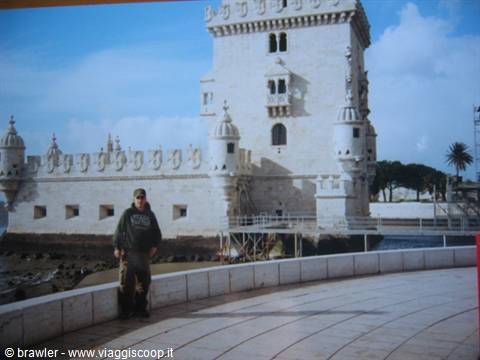 Man in green sweatshirt near Belém Tower, pale stone under the sun