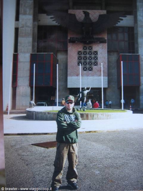 Young man standing with crossed arms in front of the eagle stadium entrance