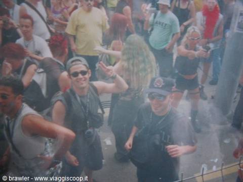 Cheering crowd dancing amid colored smoke during a street parade