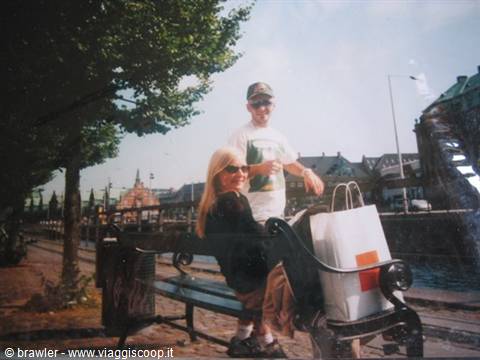 Couple with shopping bag on an iron bench by the water in Stockholm