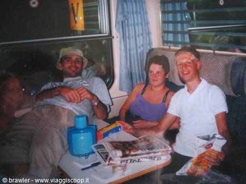 Friends on a night train sleeper, newspapers and bottle on the table