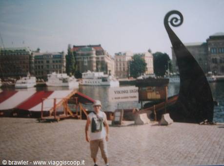 Tourist beside a Viking ship bow sculpture at Strömkajen, Stockholm
