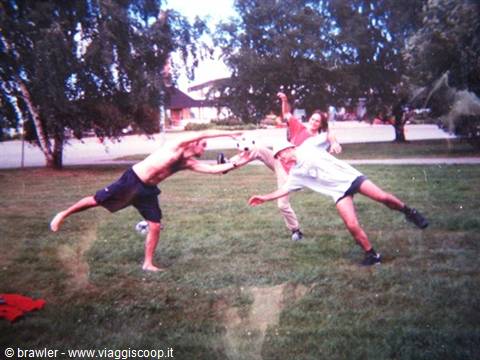 Three friends jump to hit a ball in a tree-lined park