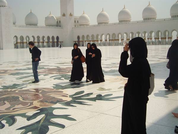 Women in abayas on the floral marble of Sheikh Zayed Grand Mosque
