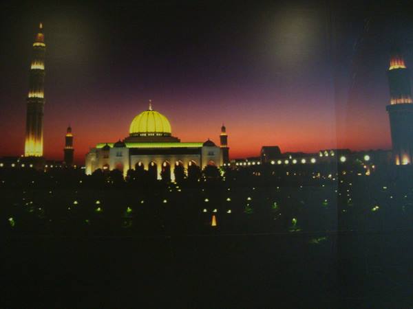 Sultan Qaboos Mosque in Muscat, golden dome and minarets lit at night