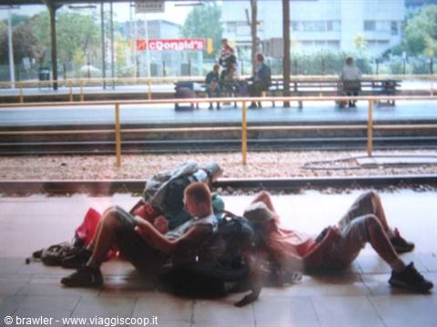 Young backpackers with backpacks resting on the station platform