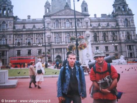 Two backpackers in George Square in front of Glasgow's Victorian City Chambers