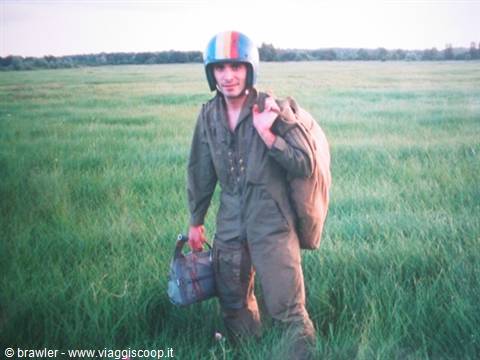 Paratrooper with striped helmet and backpack in a grassy field