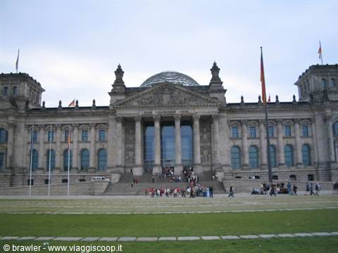 Tourists on the steps of the Reichstag in Berlin, stone facade with glass dome