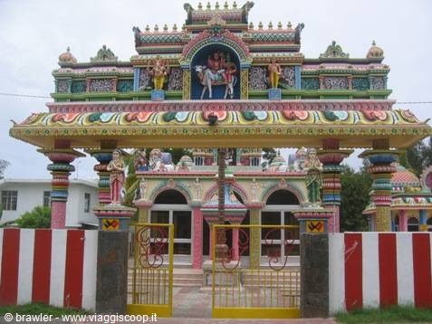 Colorful Hindu temple with painted deity sculptures, arched gateways and yellow gates