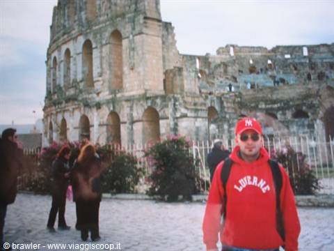 Tourist in red sweatshirt in front of the Roman amphitheatre of El Jem