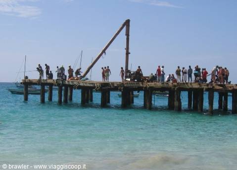 People on a wooden pier above turquoise sea water