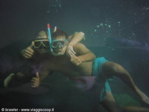 Two young men in masks and snorkels give thumbs up underwater
