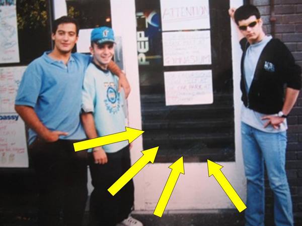 Three young men outside a record store, yellow arrows point at the window