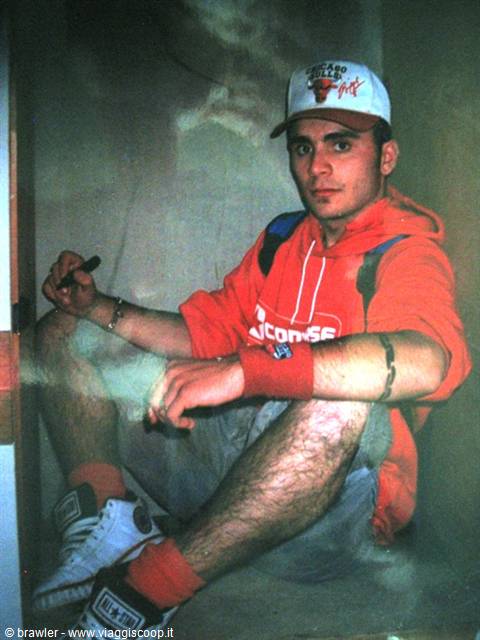 Young man in red hoodie and Chicago Bulls cap sitting on the floor indoors
