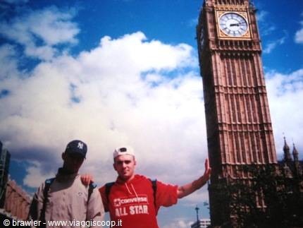 Two guys in front of Big Ben in London under a cloudy sky